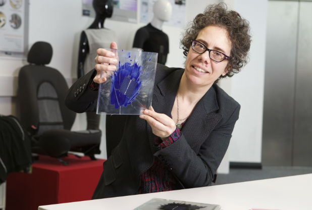 Dorothy Hardy cùng với tấm pin quang điện được thiết kế trong suốt như tấm kính với họa tiết phá cách màu xanh trên bề mặt.