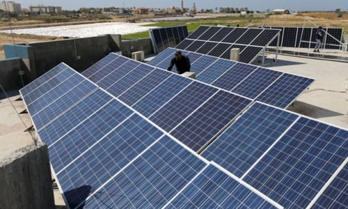 A Palestinian worker installs solar panels atop the roof of a medical centre in Gaza City March 1, 2016. REUTERS/Ibraheem Abu Mustafa