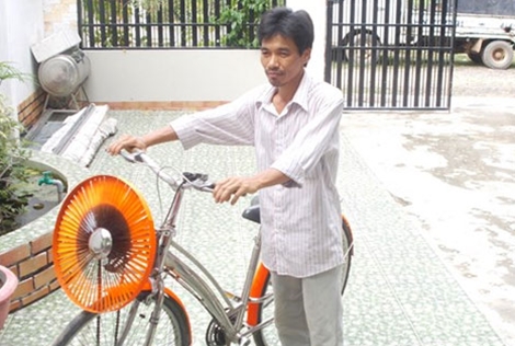 Thầy giáo Trần Đình Thuy và chiếc xe đạp có gắn tuabin gió.